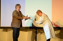 京都造形芸術大学の本間正人副学長（左）から委任状を受け取る水道橋博士（右）。