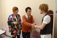 おばたのお兄さん扮する小栗旬に握手を求める井上小公造（中央）。