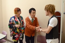 おばたのお兄さん扮する小栗旬に握手を求める井上小公造（中央）。