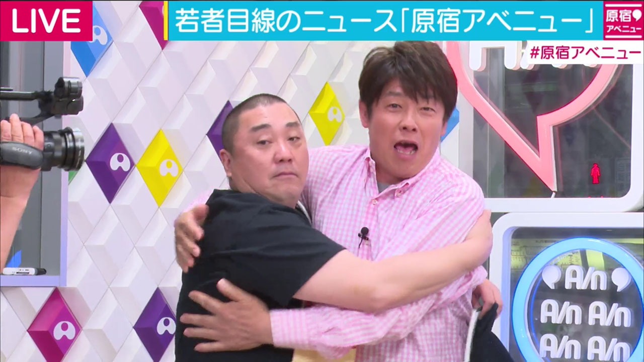 TIMレッド吉田（右）とハグする極楽とんぼ山本（左）。