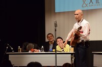 参加者によるギター漫談を聴く大竹まこととカミナリ。