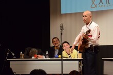 参加者によるギター漫談を聴く大竹まこととカミナリ。
