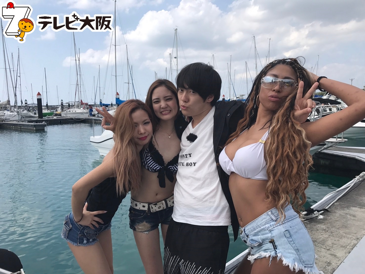 水着女性たちと写真を撮影するウーマンラッシュアワー村本（右から2番目）。