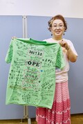 見舞いに来てくれた人たちにメッセージを書いてもらっていたTシャツを見せる宮川花子。