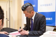 サインを入れる笑い飯・哲夫。