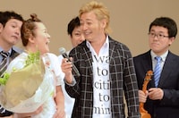 誕生日祝いの花束を受け取る山田邦子（左）。