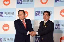 握手を交わす金田勝年法務大臣（左）と西川きよし（右）。