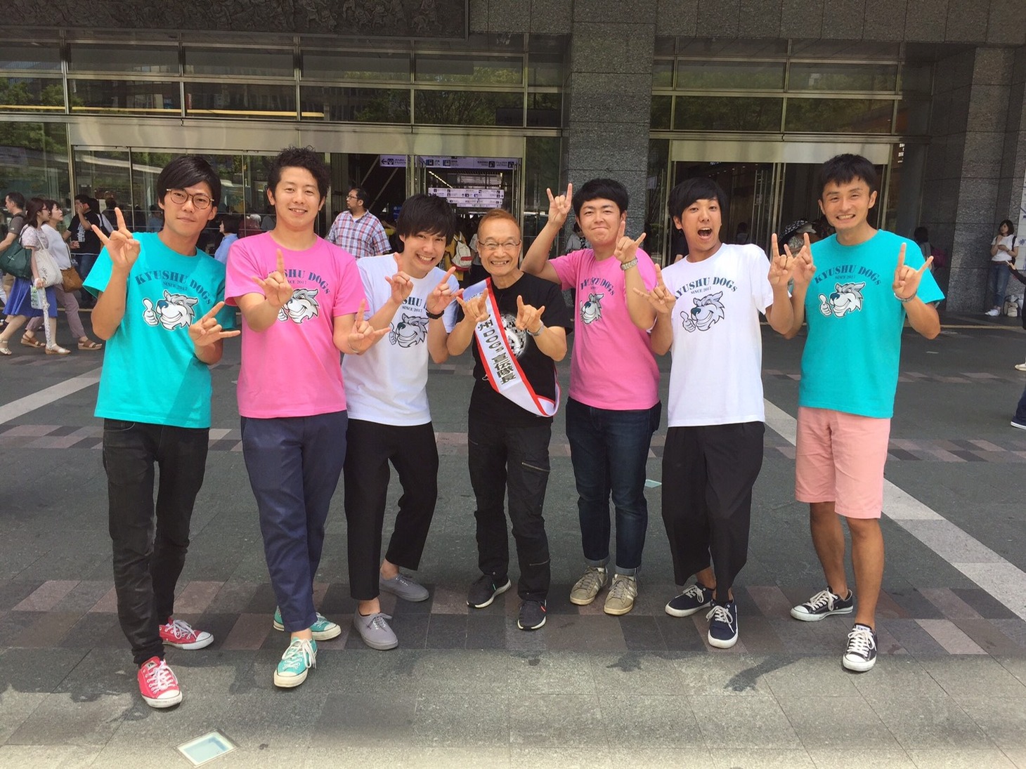 ロケ中に遭遇した神谷明（中央）と記念撮影する九州DOGs。