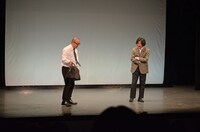 マツモトクラブ（右）が舞台に忘れていったカバンを拾うルシファー吉岡（左）。