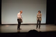 マツモトクラブ（右）が舞台に忘れていったカバンを拾うルシファー吉岡（左）。