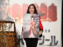 昔に撮った自身の写真を見せる平野ノラ。