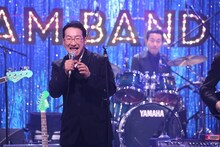 春風亭昇太と、ドラムを叩く三宅裕司。