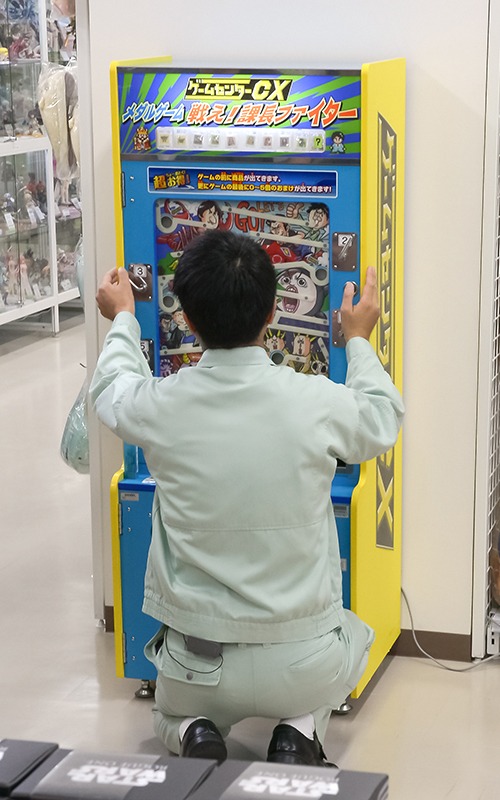 メダルゲーム「戦え！課長ファイター」で有野課長が遊ぶ後ろ姿。