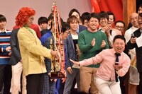 アイデンティティを「おめでとちゃーん」と祝福する、インスタントジョンソンゆうぞう（手前右）。