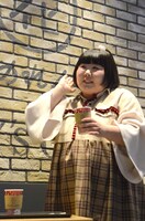 赤のカフェラテを試飲する酒井藍。