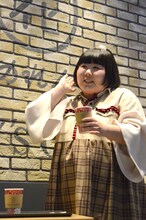 赤のカフェラテを試飲する酒井藍。