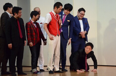 対決に敗れて土下座し、変顔を披露するエルシャラカーニ・セイワ。