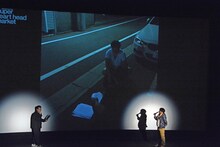 稽古場の外で練習する日村の写真を見るバナナマン。