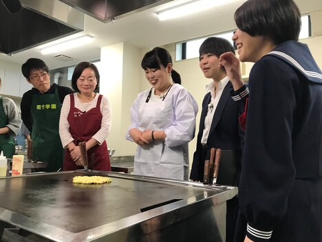 おいしいお好み焼きの作り方を指導されるブルゾンちえみ（中央）。(c)ABC