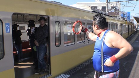 駅のホームでタンバリン芸を披露するゴンゾーと、それを電車の中から見守るピエール瀧。(c)静岡朝日テレビ