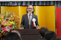 「沖縄ラフ＆ピース専門学校」入学式で挨拶する古賀俊輔氏。
