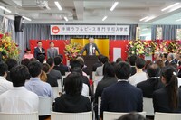 「沖縄ラフ＆ピース専門学校」入学式で挨拶する堀江信彦氏。