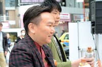 集まった人に直接ボトルを手渡すかまいたち山内（手前）。