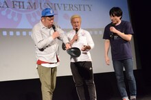 曲がったフライパンの使い道を「シチュー用？」と尋ねる野性爆弾くっきー（左）。