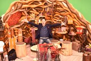 「世界!極タウンに住んでみる」のセットを背景にして写真撮影に応じる東野幸治。