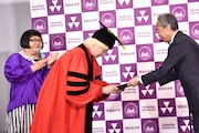 同志社大学副学長の藤澤義彦氏(右)に1日学長の委嘱状を手渡されるカズレーザー(中央)。