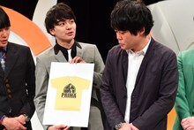 Tシャツのデザインを披露するプリマ旦那。