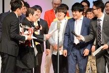 賞状やトロフィーを受けとるおちもり。