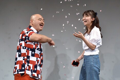 紙吹雪をまくクロちゃん(左)と、小嶋真子(右)。