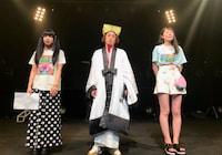 「やついフェスキャンペーンガール」グランプリを受賞した田中しろめ（左）と安藤きらり（右）に挟まれるエレキコミックやつい（中央）。