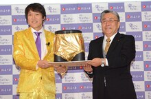 宣伝部長就任を記念して“黄金のパンツ”をプレゼントされた千原ジュニア（左）。