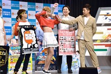 女装するレインボー池田がポーズを決めた場面。