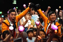 「夏はウルフェスー！」のかけ声を、会場の家族連れと揃える爆笑問題。