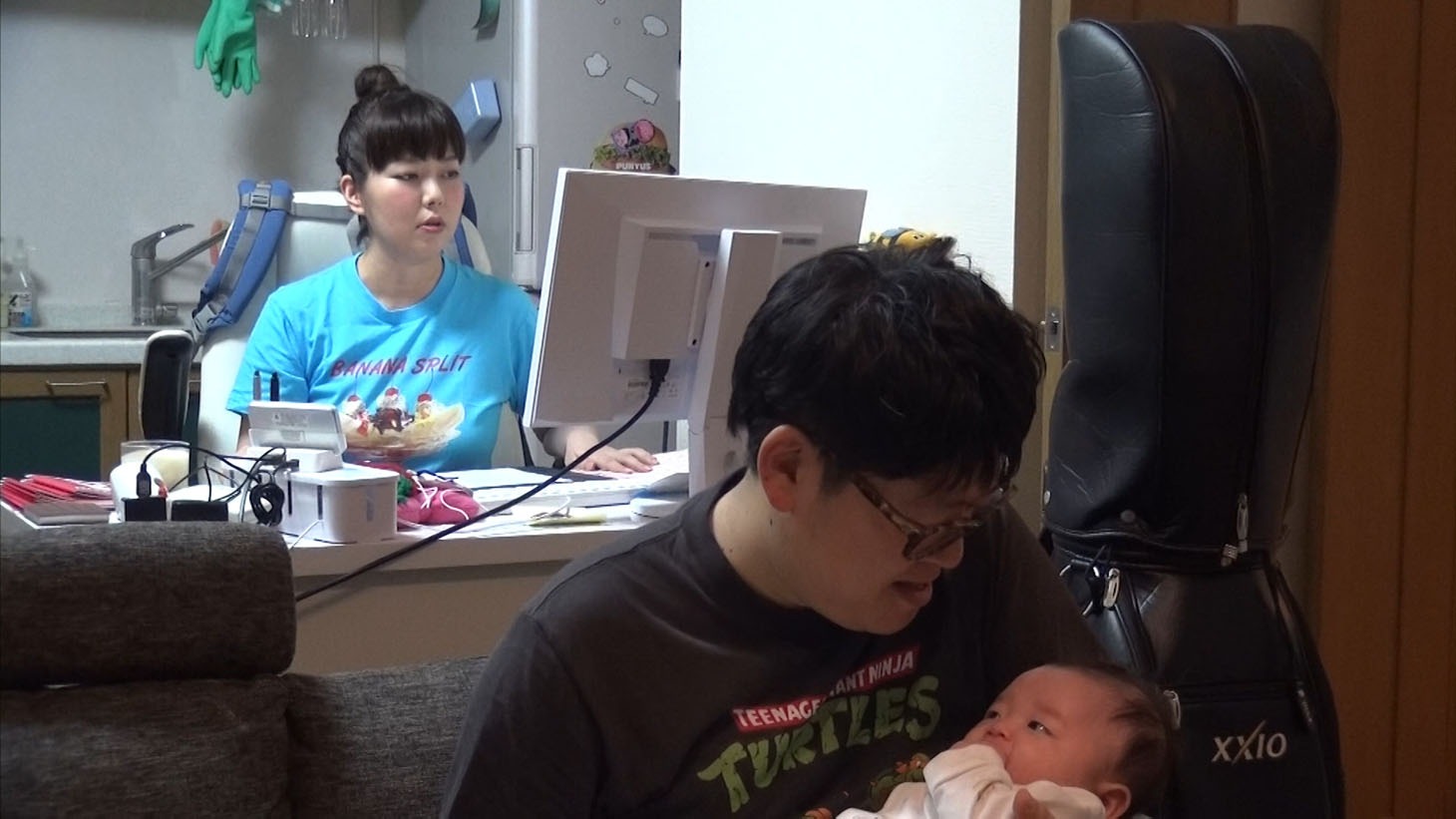 仕事をする大貫さん（左）と子守りする山西（右）。 (c)MBS