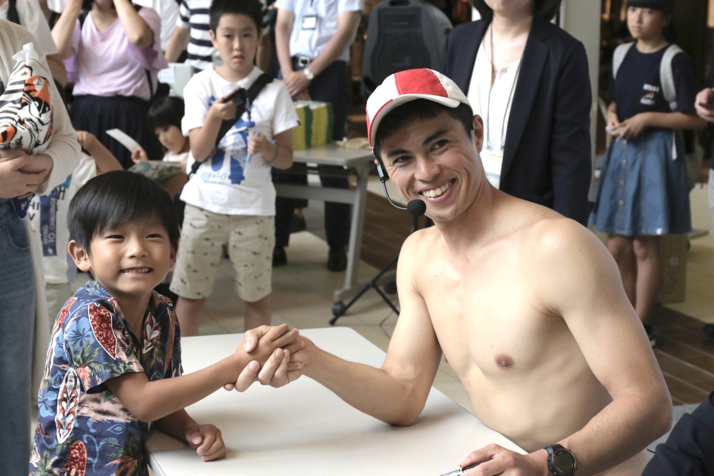 サイン＆握手会に臨む小島よしお（右）と子供たち。