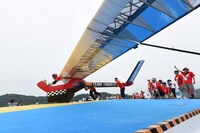 滑空機に乗って飛び立つ三四郎・小宮。