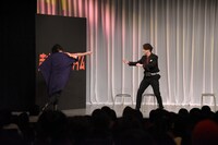 変身に際しメダルを手渡す三浦（左）と、それを受け取る渡部。