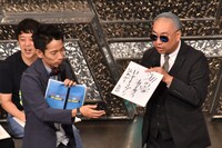 「海の家あるある」を書いた色紙を、お題を提供したファンにプレゼントするレイザーラモンRG（右）。