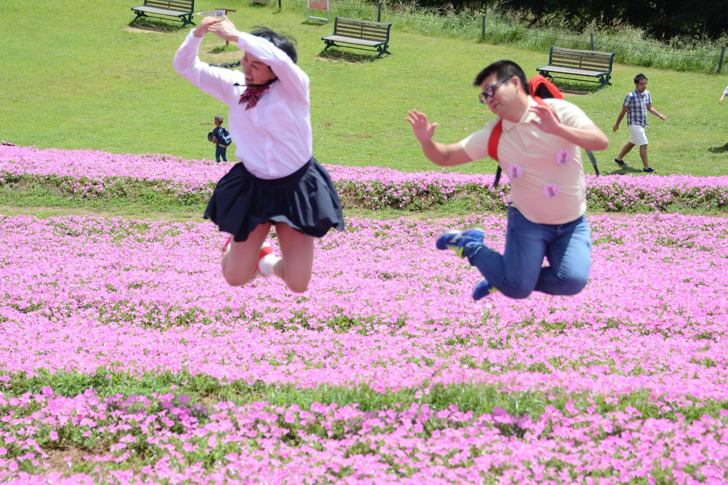 花畑でジャンプする（左から）如月マロン、ごろうさん。