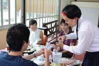 ツアー参加者にお酌する如月マロン。