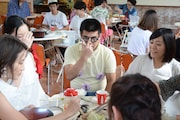 ツアー参加者に囲まれながらジンギスカンを食べるごろうさん。