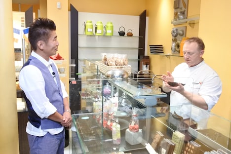 フランス・パリ市内のパンとスイーツの店の店主にかつおぶしを渡す勝俣州和（左）。(c)SBS