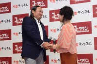 会見にて握手を交わすロバート秋山（左）と友近（右）。