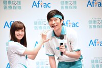 「あーん」の瞬間がフォトタイムになり、戸惑いながらも笑顔を見せる橋本環奈（左）と田中圭（右）。