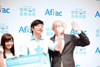 フォトセッション時、カメラに手を振りながらわざとあばれる君（右）の顔を隠す田中圭（中央）。