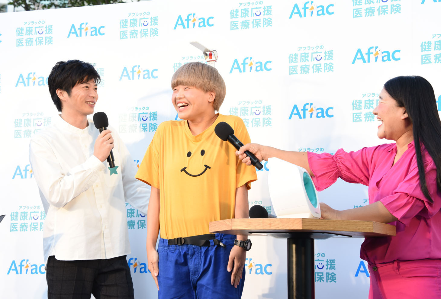 田中圭に身長を測ってもらうガンバレルーヤまひる（中央）。